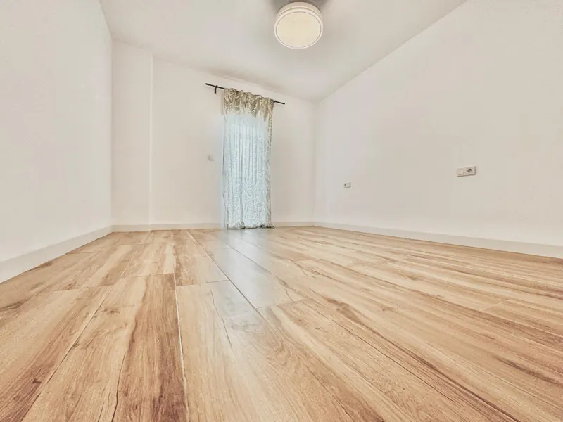 Salón con suelo laminado roble recién instalado sobre el suelo antiguo, en un piso de Córdoba